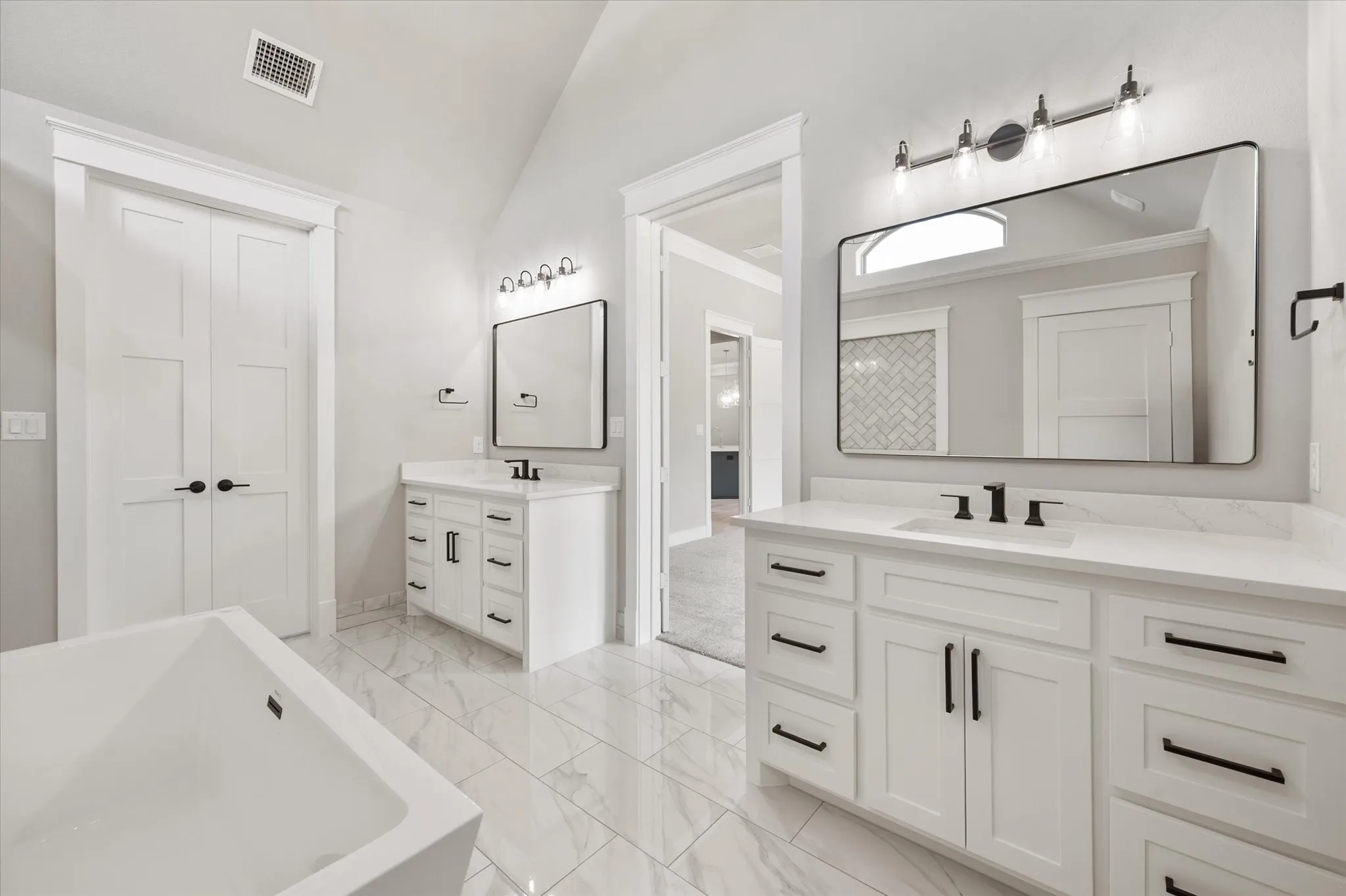 Dual vanities with white cabinetry, quartz countertops, and matte black hardware