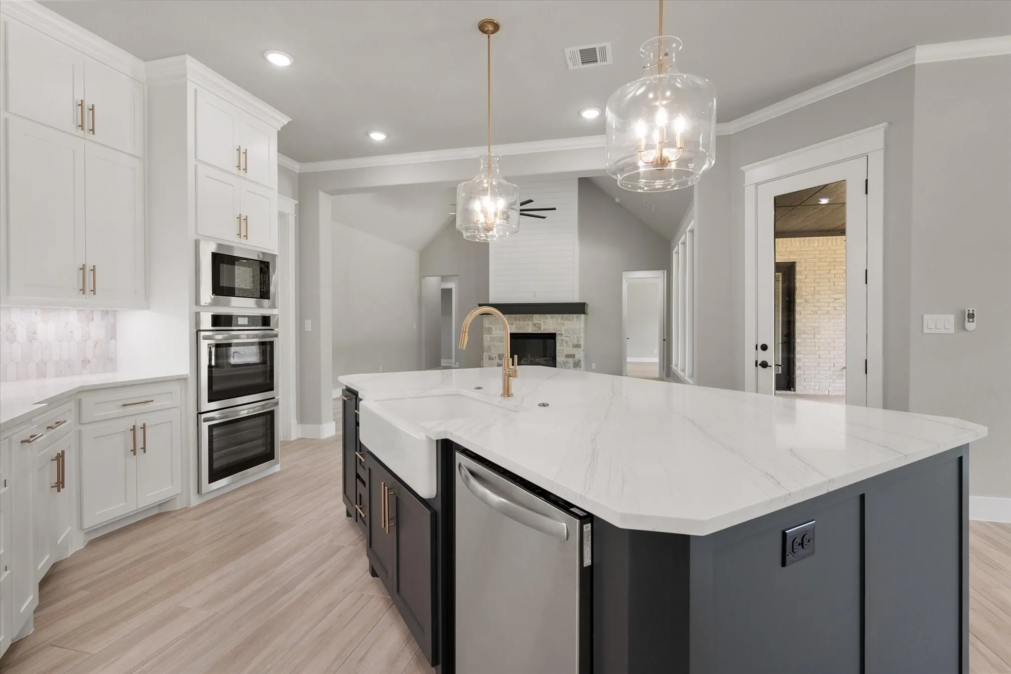 Kitchen island with a farmhouse sink and gold-tone faucet