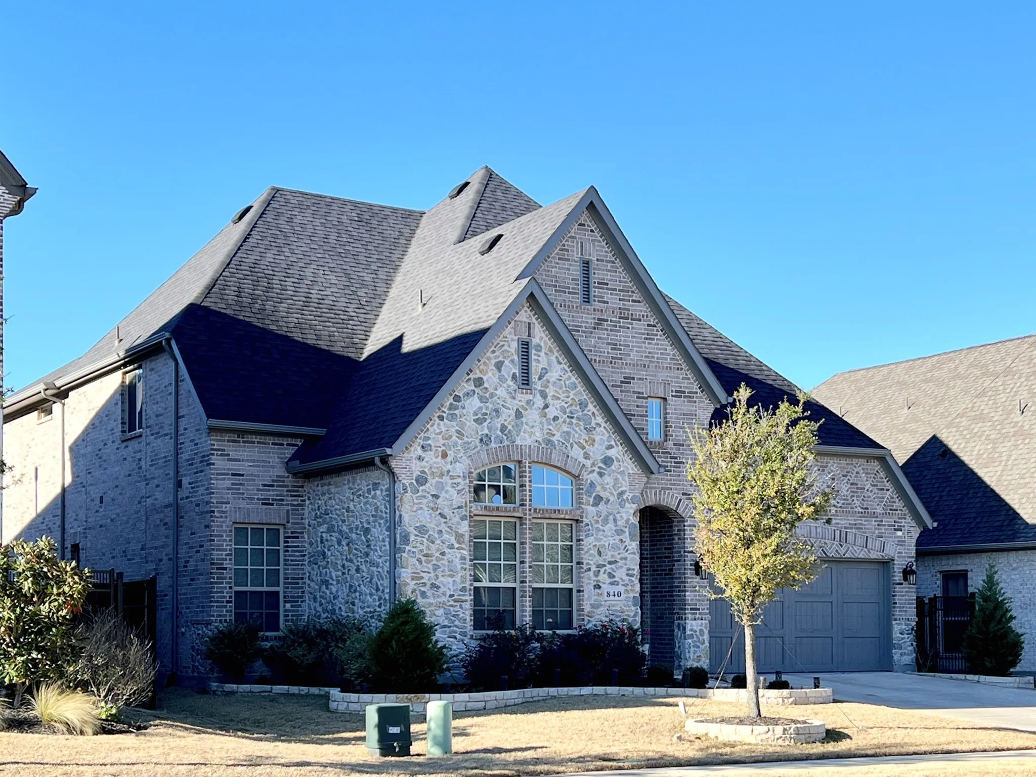 Front of 840 Moorland Pass Dr, brick and stone veneer, front garage door.