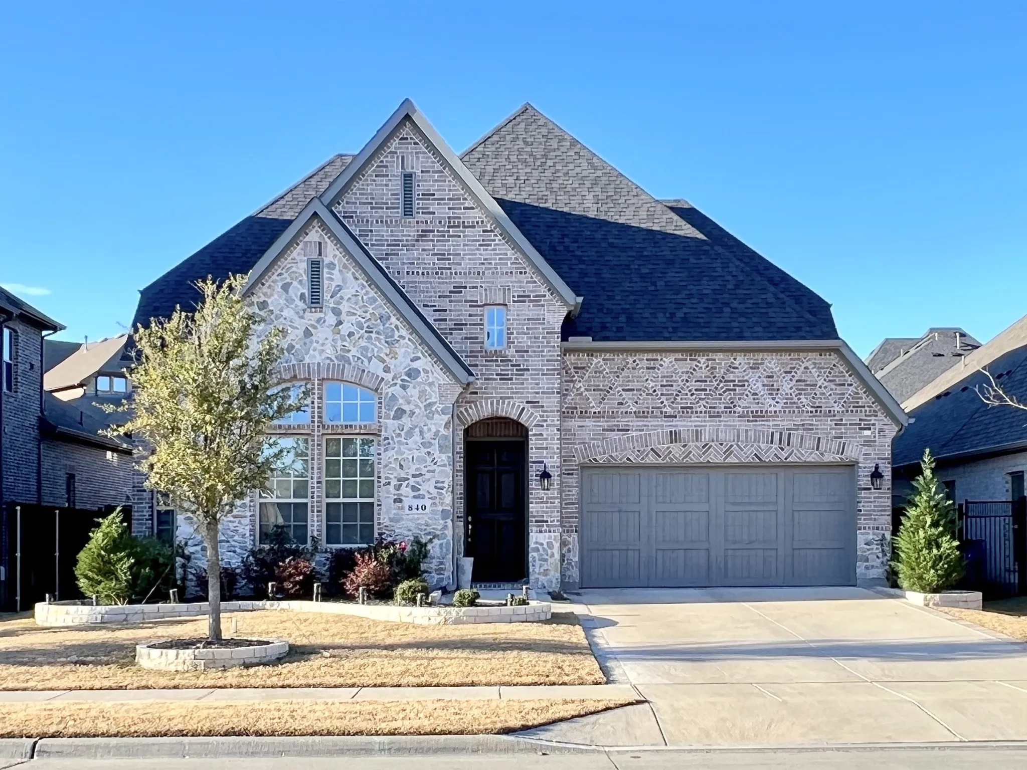 Front of 840 Moorland Pass Dr, brick and stone veneer, front garage door.