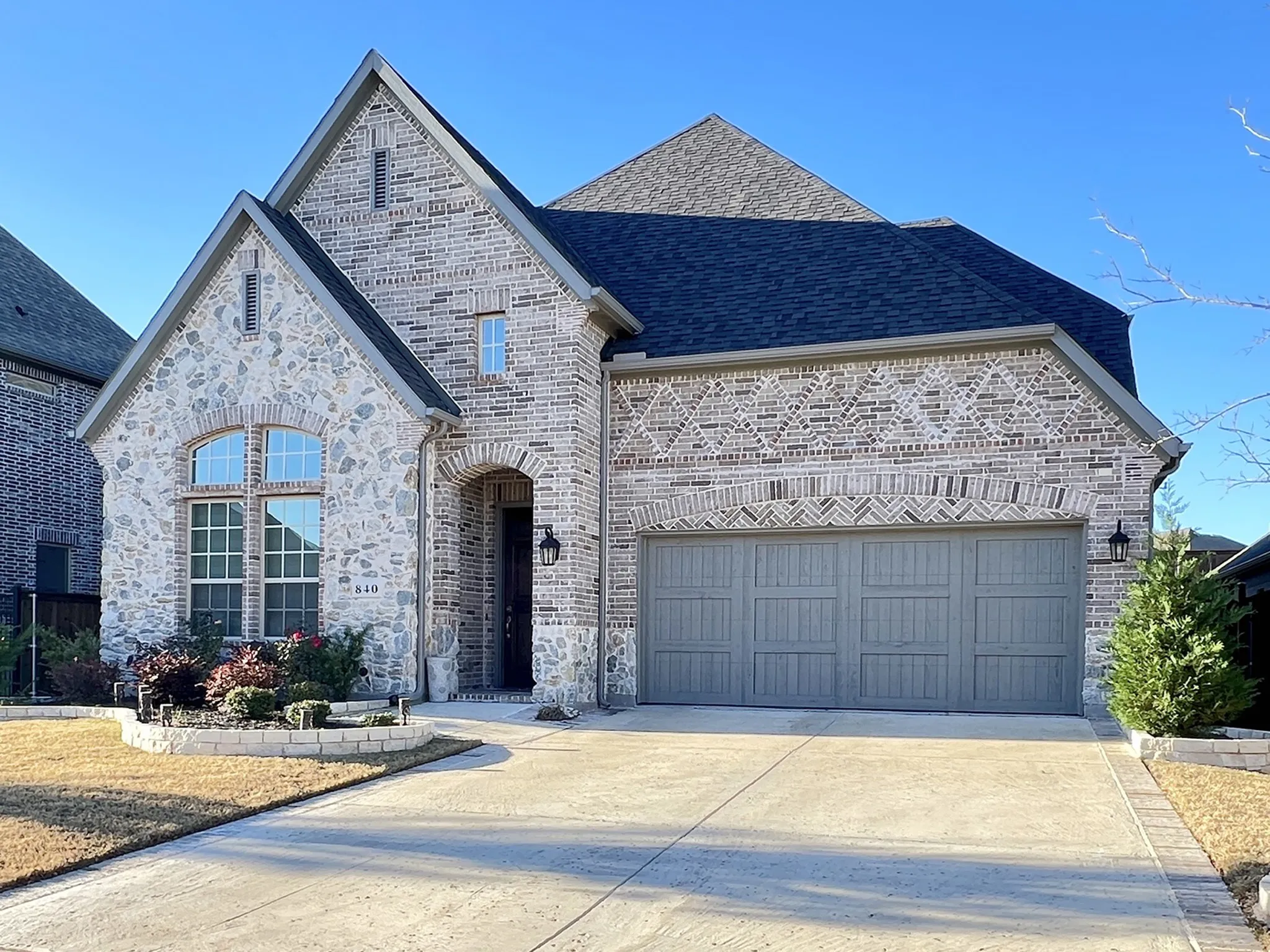 Front of 840 Moorland Pass Dr, brick and stone veneer, front garage door.