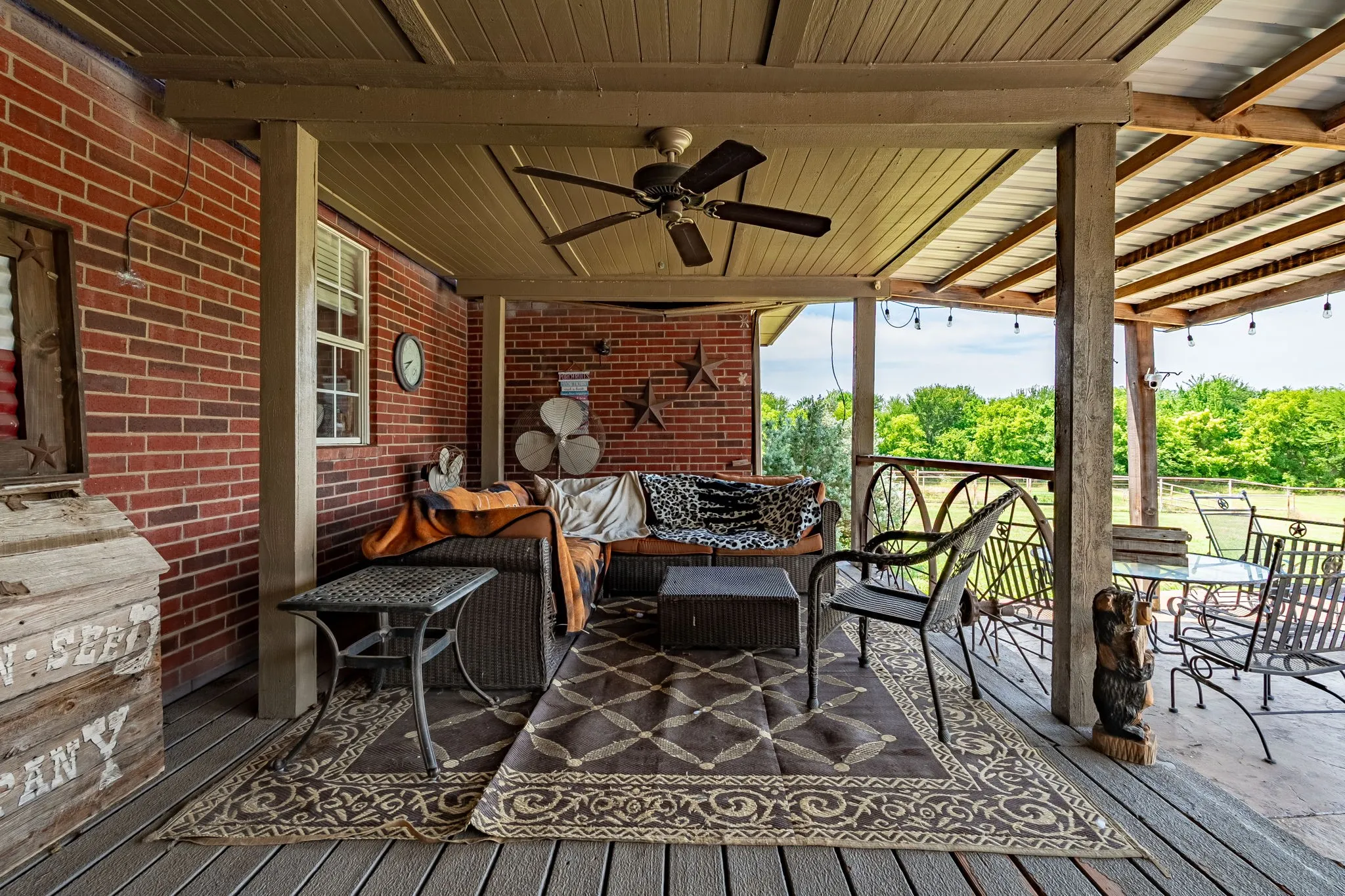 Covered patio featuring a wood-finish ceiling with a ceiling fan, brick wall, and wood-finish flooring