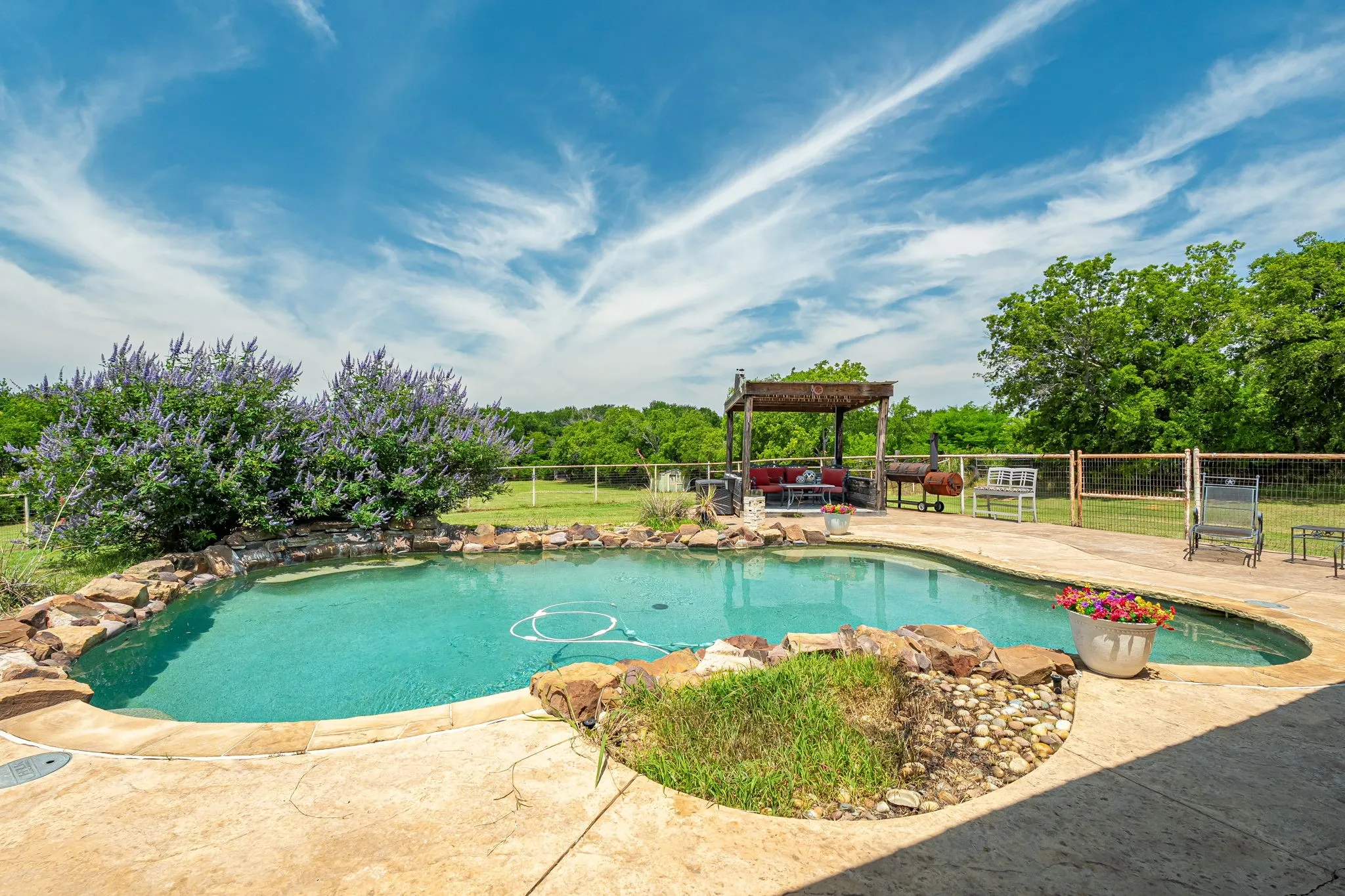 Freeform swimming pool with rock coping and integrated landscaping
