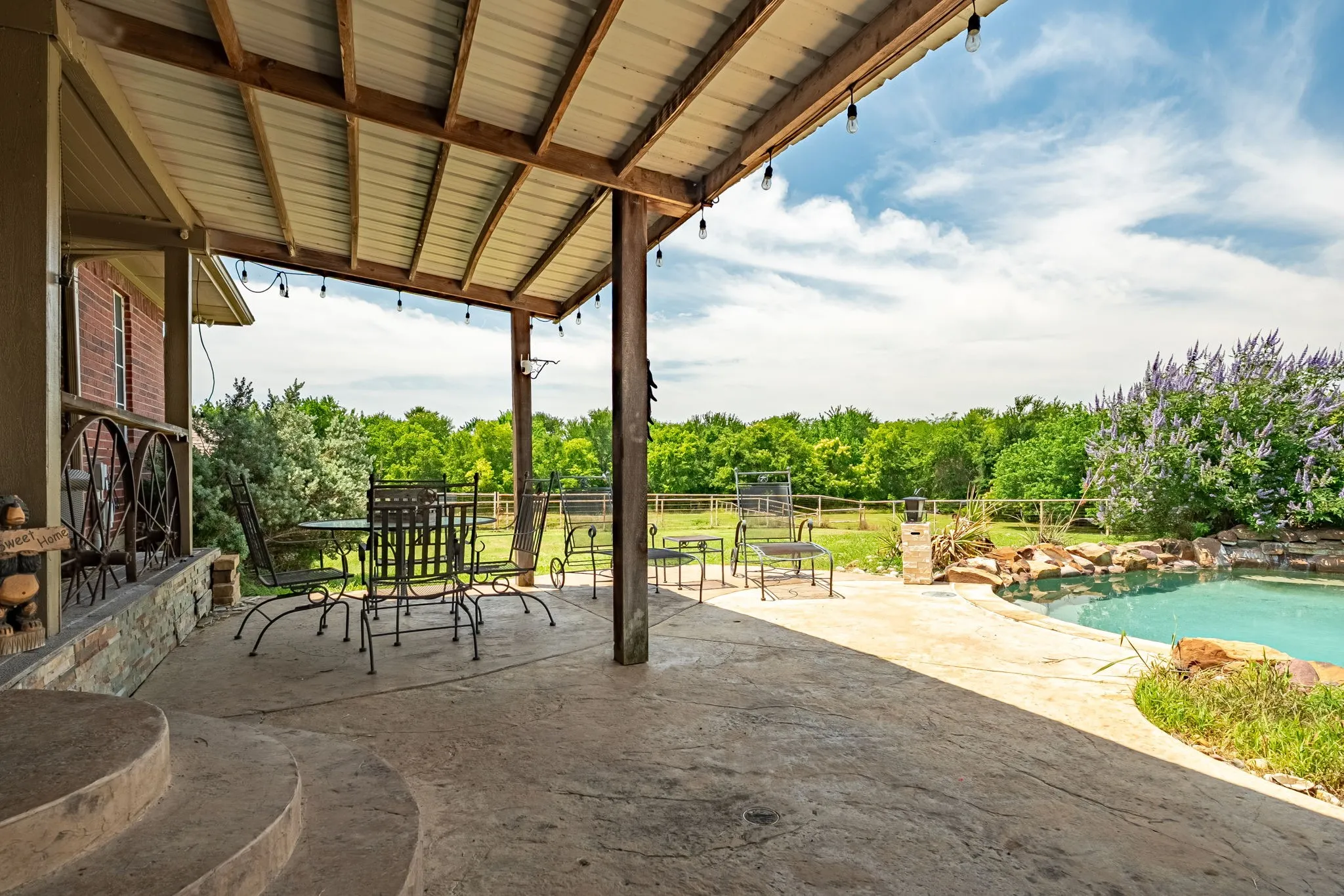 Covered patio featuring a metal roof and exposed wood beams