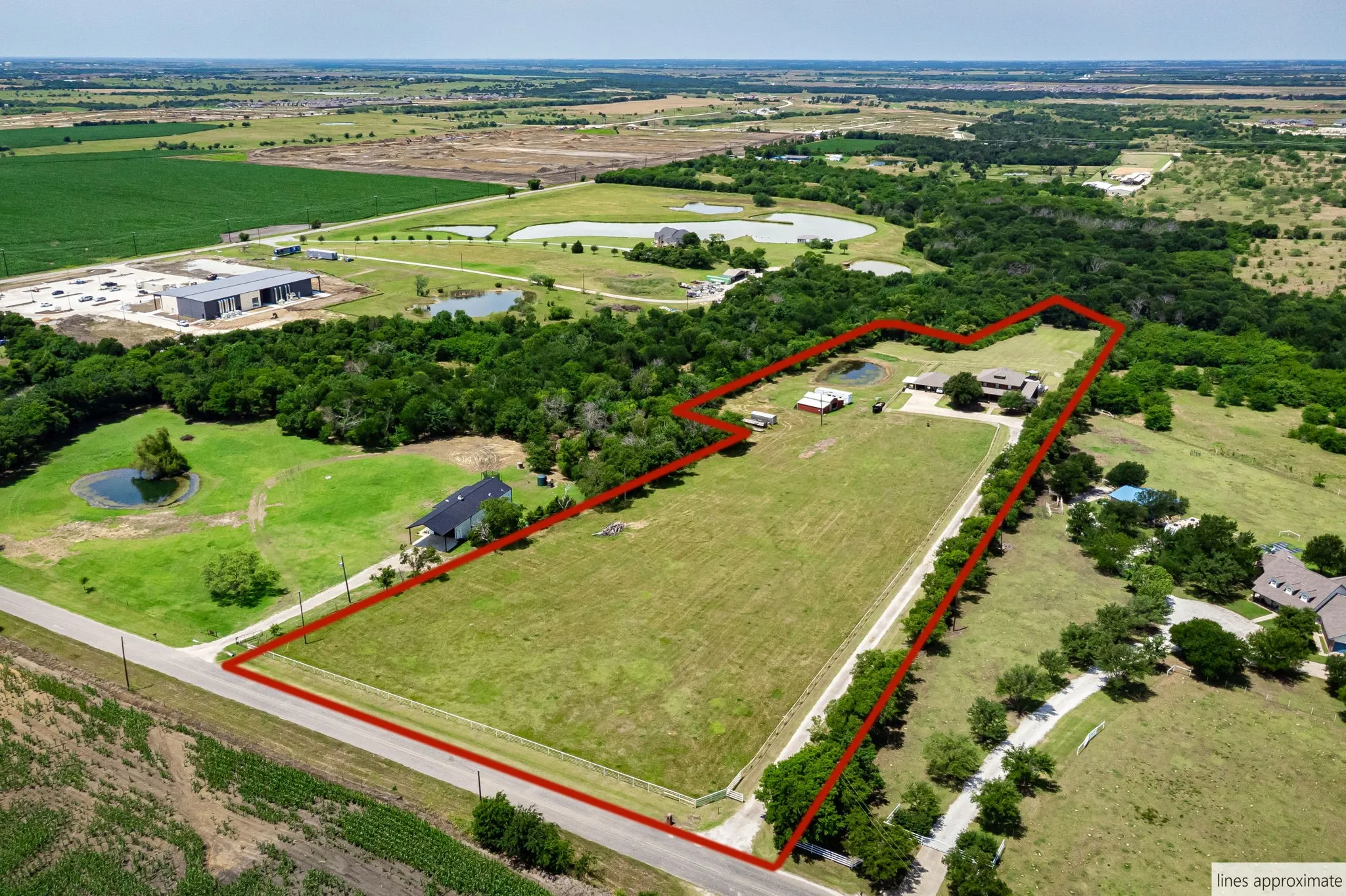 Expansive acreage featuring a main residence, secondary structure, a pond, and dense tree coverage