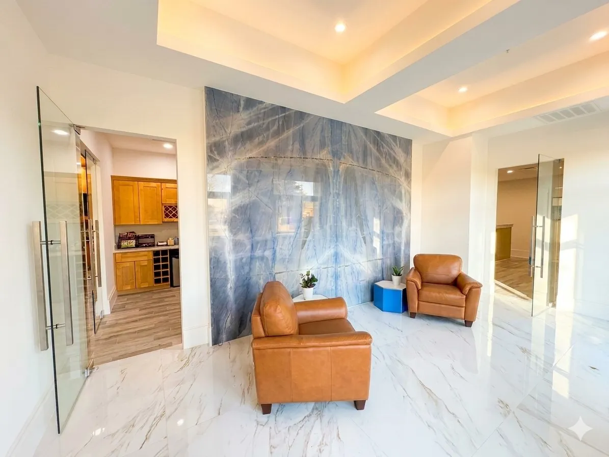 Large format tile flooring, accent wall, tray ceiling with recessed lighting, clear glass entry doors, built-in cabinetry
