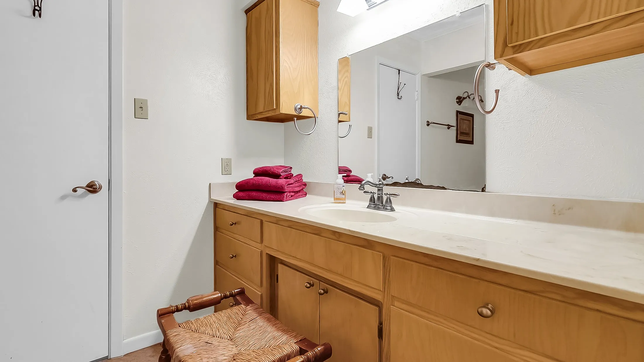 Bathroom vanity featuring a light-toned countertop with an integrated sink and chrome faucet