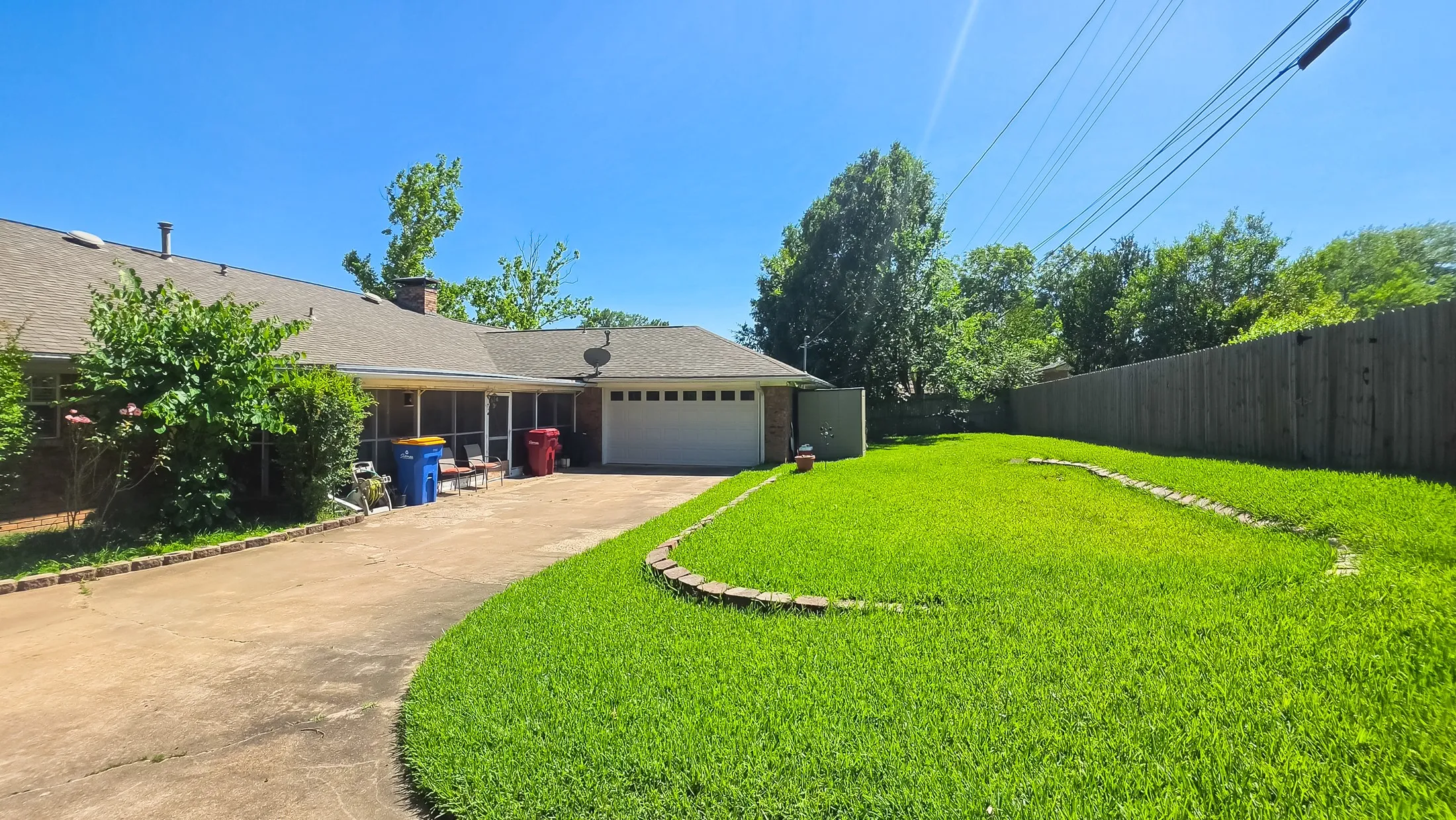 Expansive backyard featuring a lush lawn and a wood privacy fence