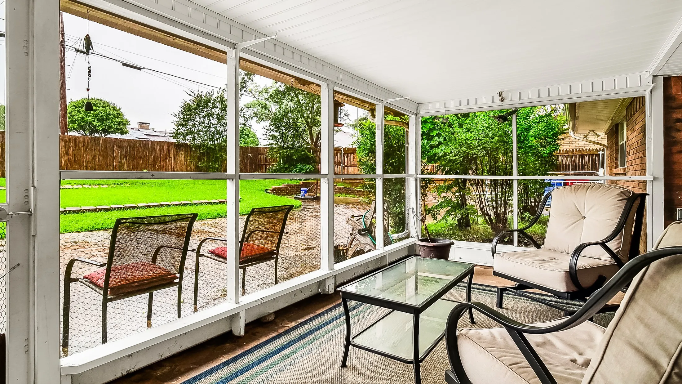 Screened porch with a white paneled ceiling, offering expansive views of the outdoor space