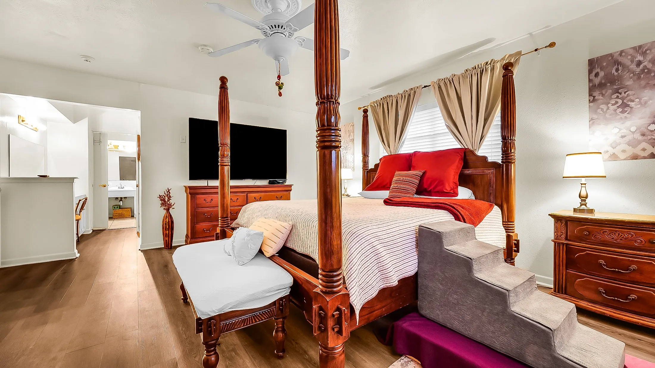Spacious interior featuring wood-finish flooring, a ceiling fan, and window blinds