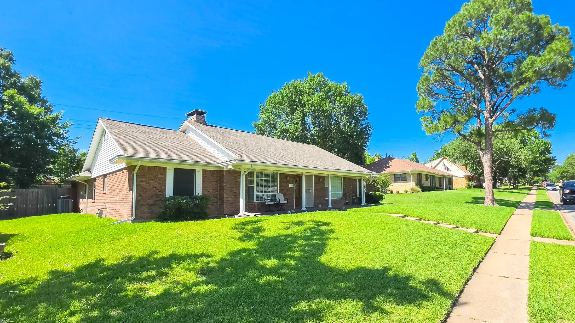 Brick residence featuring a gabled roofline and front porch