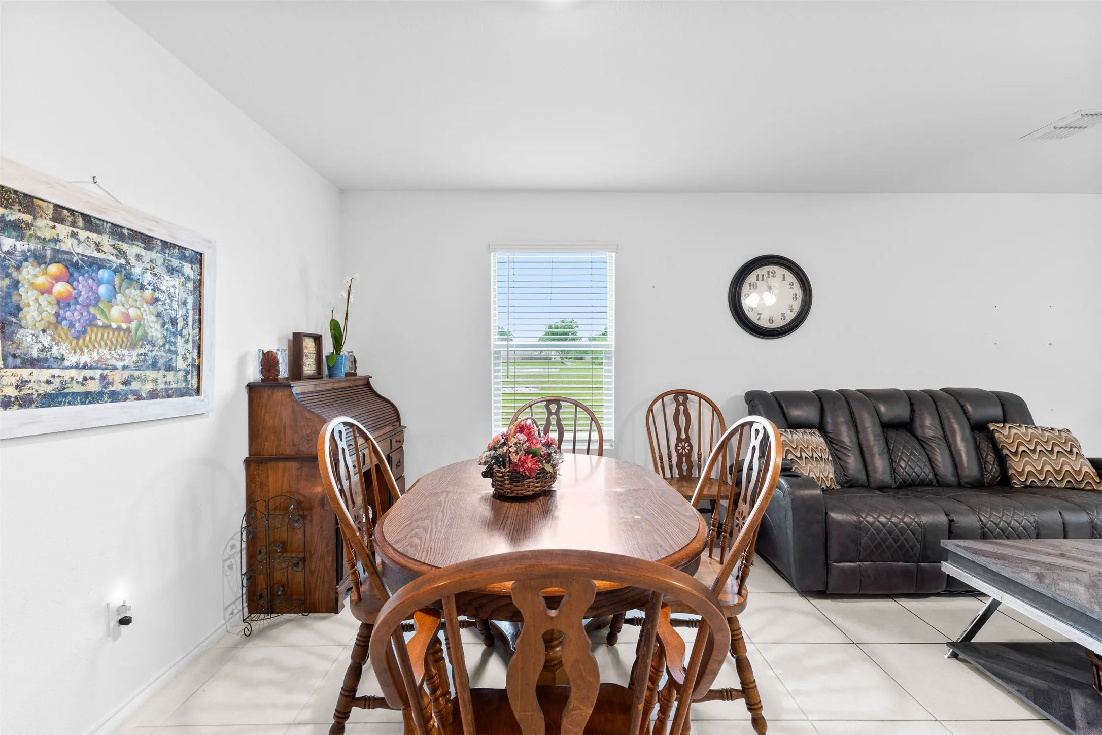 Open-concept living area with neutral walls and white tile flooring