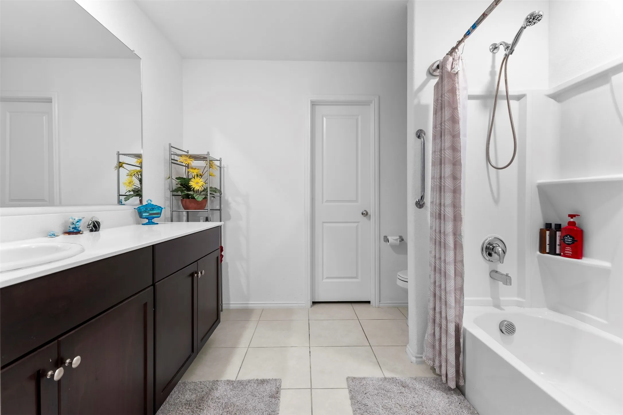 Bathroom featuring a dark wood-finish vanity with a white countertop and integrated sink
