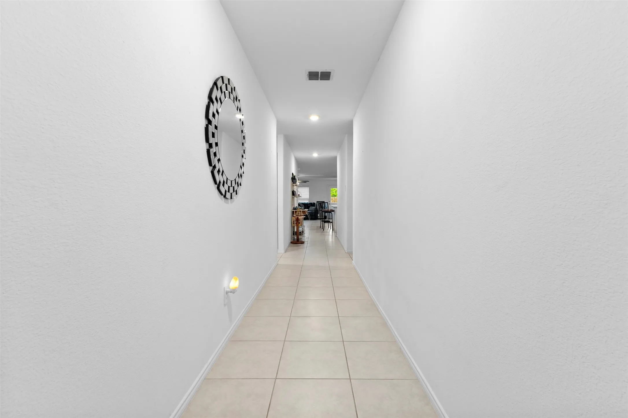 Hallway featuring square tile flooring, recessed lighting, and a wall-mounted night light