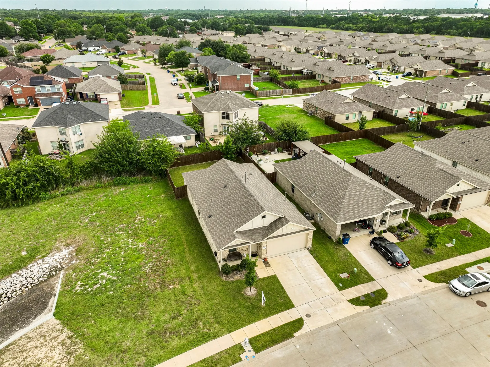 Expansive residential development featuring numerous single-story and two-story homes with shingle roofs