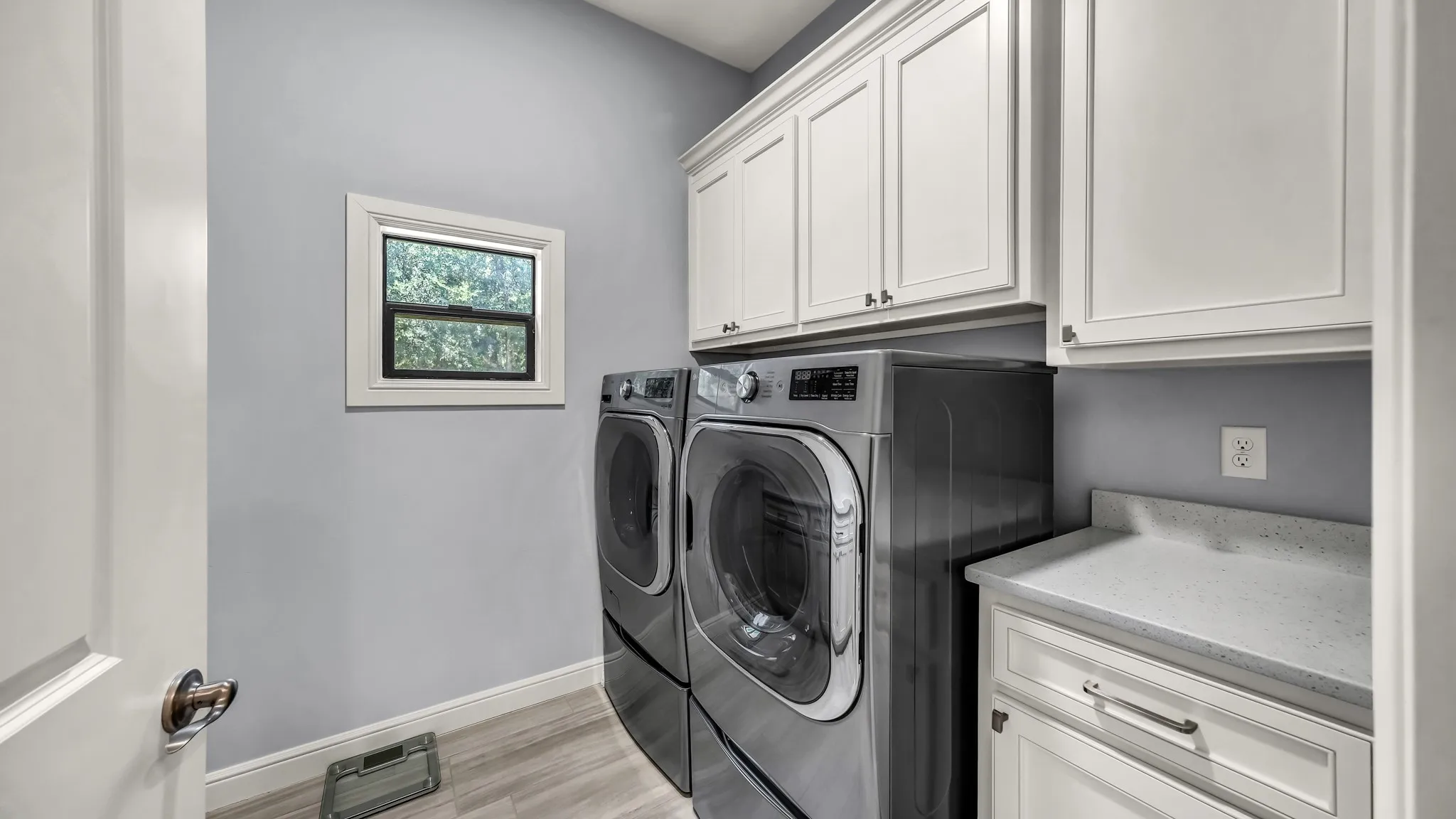 Second laundry room. This one is located through the primary bedroom closet. Has cabinets and countertop behind the door, the length of the room.