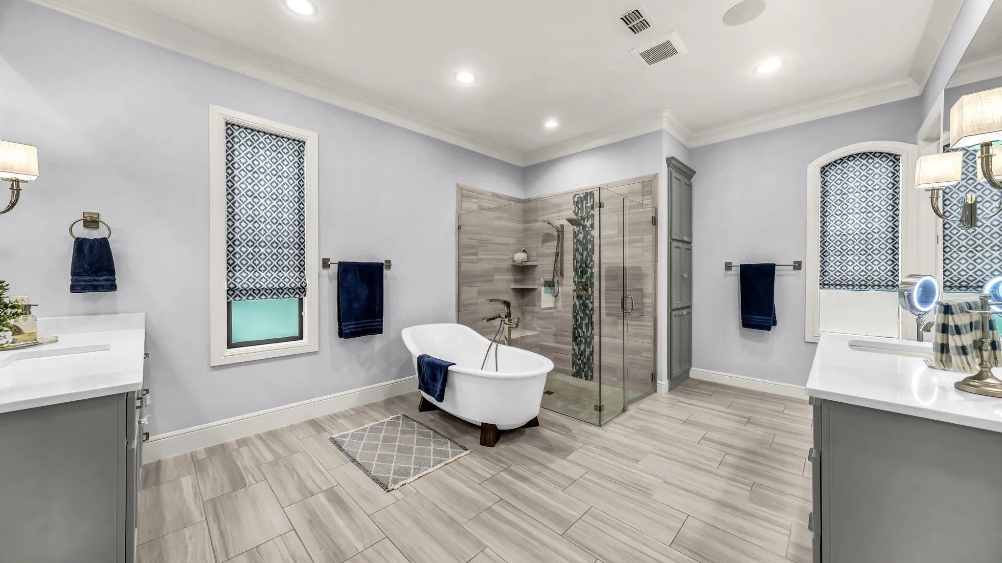 Dual vanities, separate tub and an extensive shower with a bench. Linen closets are just past the shower on the left.