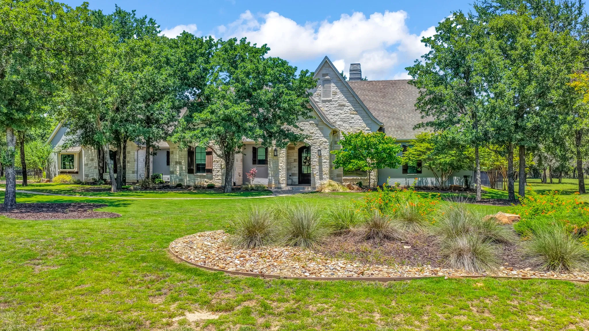 Gorgeous Will Steed Custom Home with mature trees and garden islands throughout.