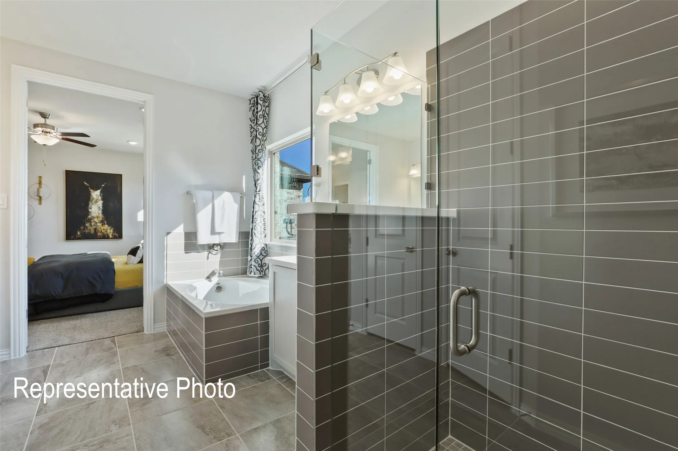Contemporary bathroom featuring a glass-enclosed shower with horizontal gray tile, an inset bathtub, and a single vanity with a mirror and light fixture
