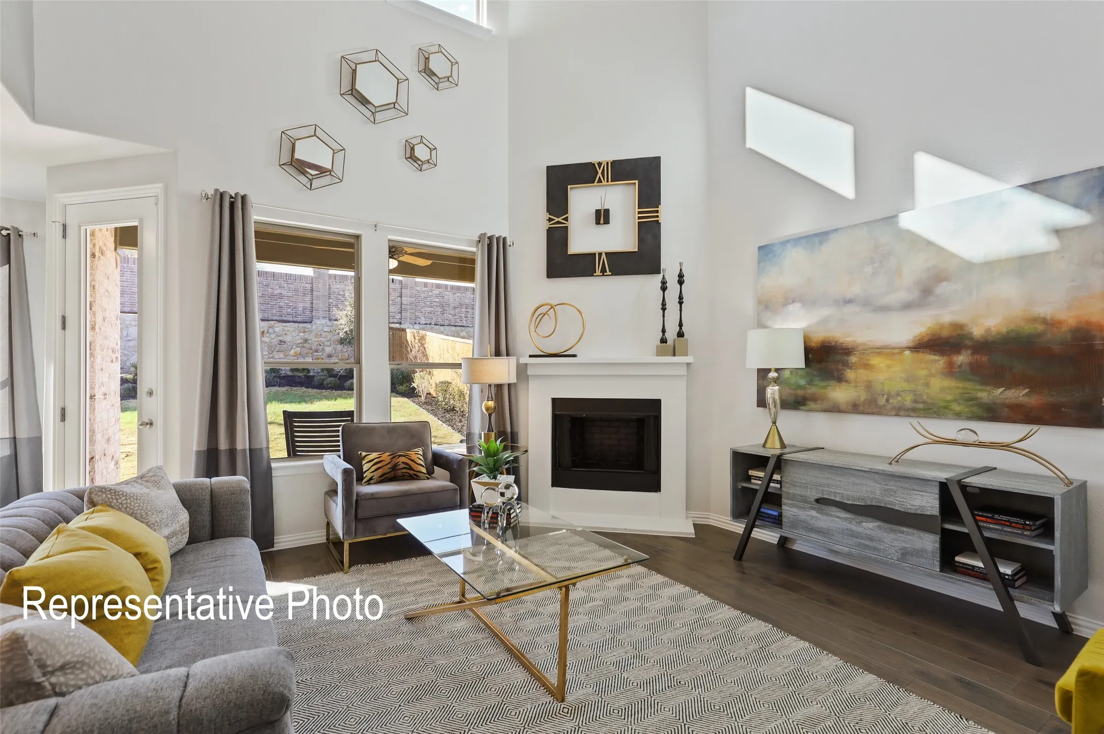 Living area featuring a white fireplace with a dark firebox, tall ceilings, and wood-finish flooring