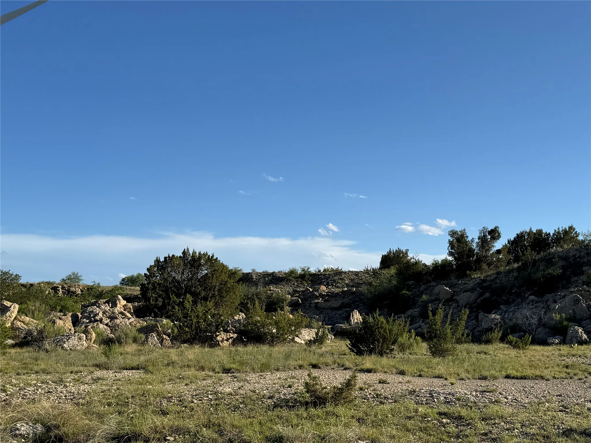 Expansive undeveloped lot featuring natural rock formations, varying elevations, native shrubbery, and a mix of arid ground cover