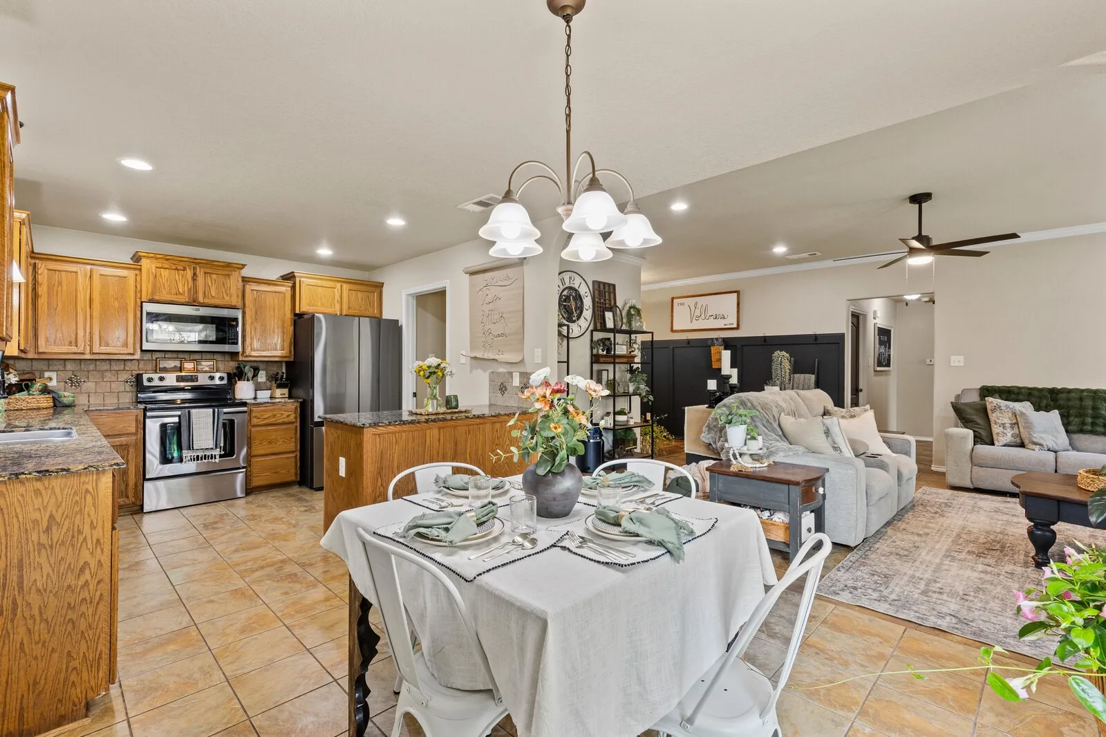 Open-concept living space featuring a kitchen with wood cabinetry, stainless steel appliances, and a central island