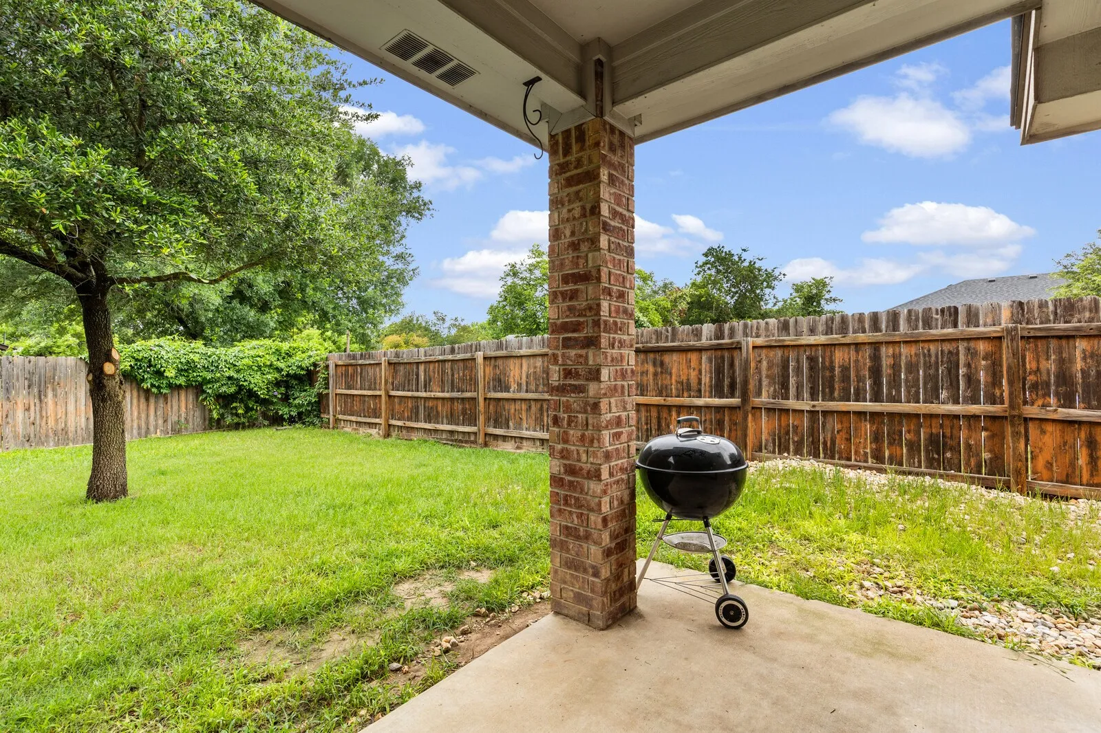 Covered patio featuring a brick support column and concrete flooring