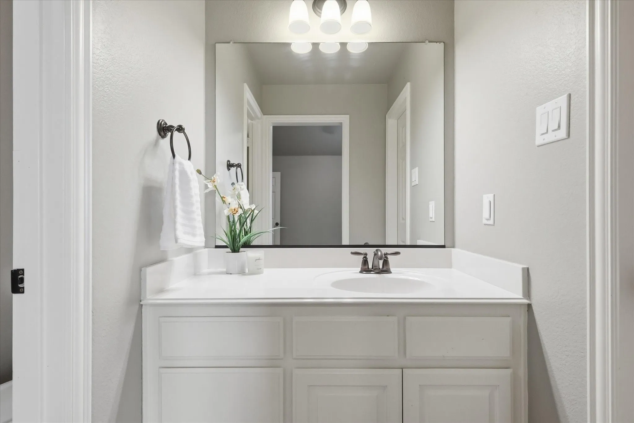 2253 Big Valley Circle, Allen, TX 75013 - bathrrom - White vanity with an integrated sink, bronze-finish faucet, and coordinating wall-mounted towel ring