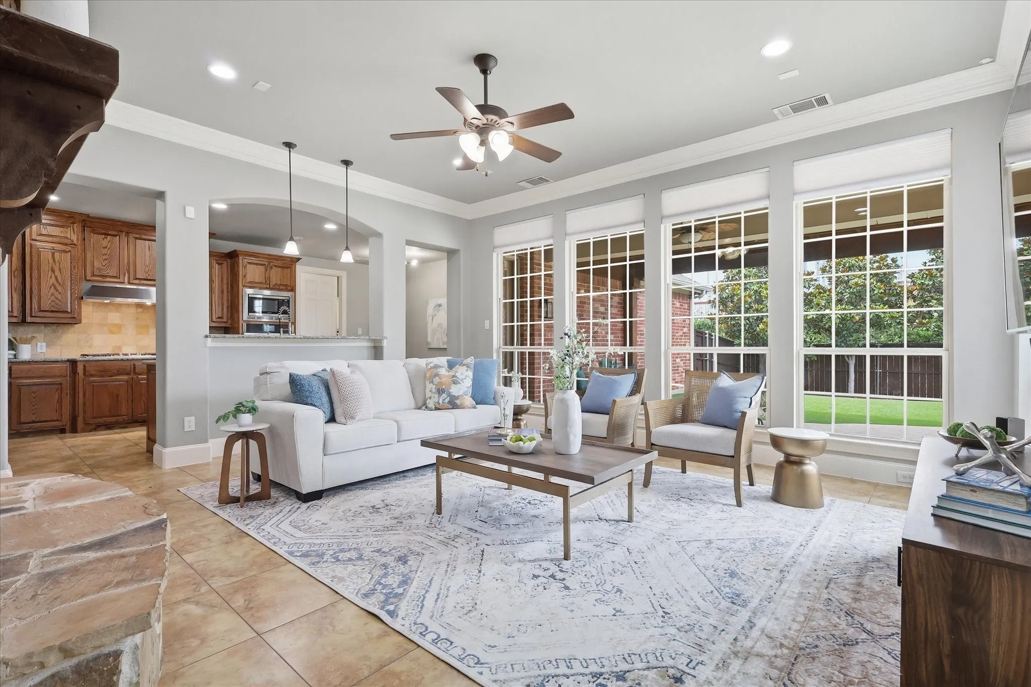 2253 Big Valley Circle, Allen, TX 75013 - Living room - Spacious living area featuring large grid windows, tile flooring, and a stone fireplace