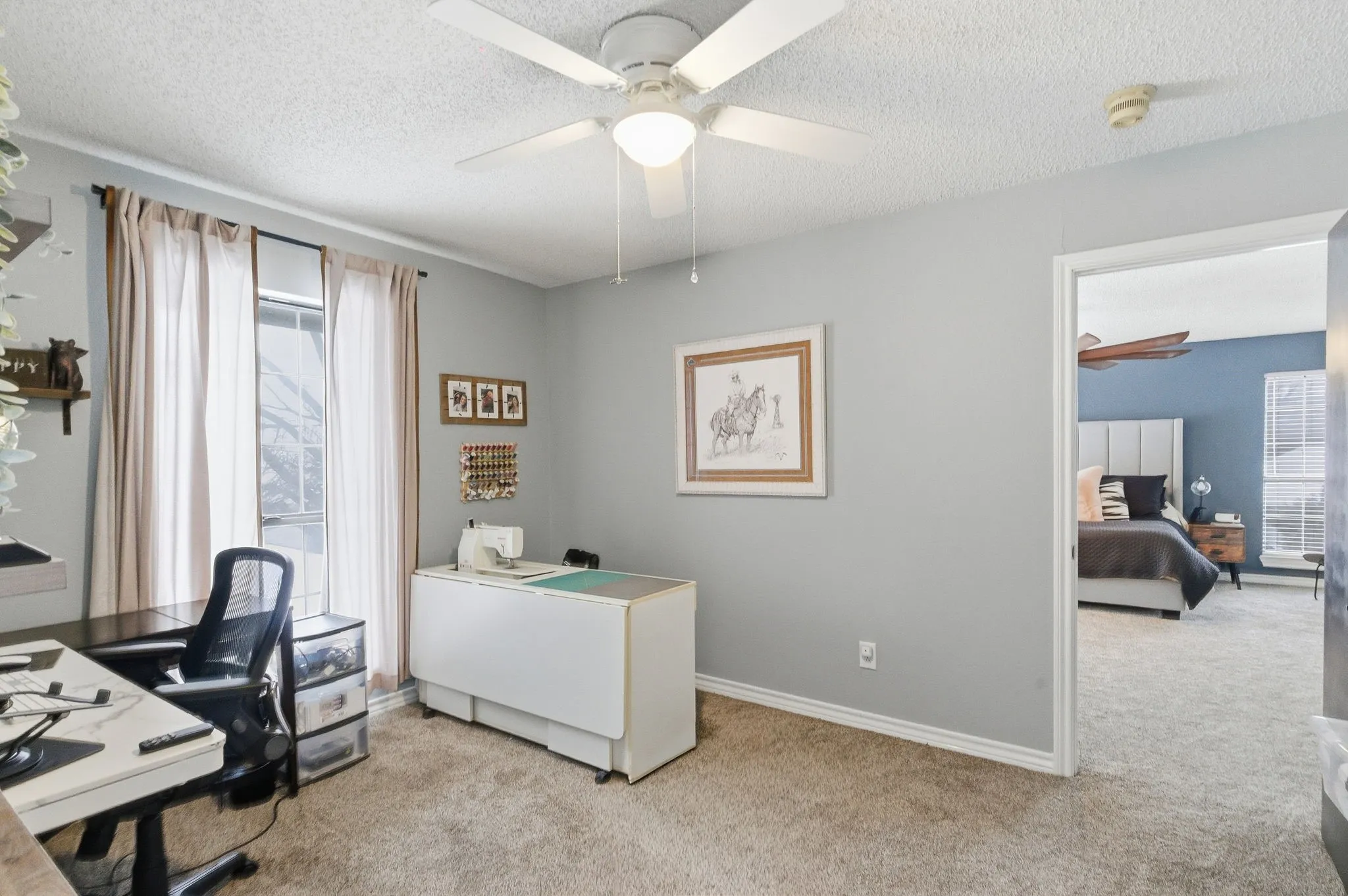 Carpeted room with light gray walls, a window with vertical blinds, a ceiling fan, and white baseboards