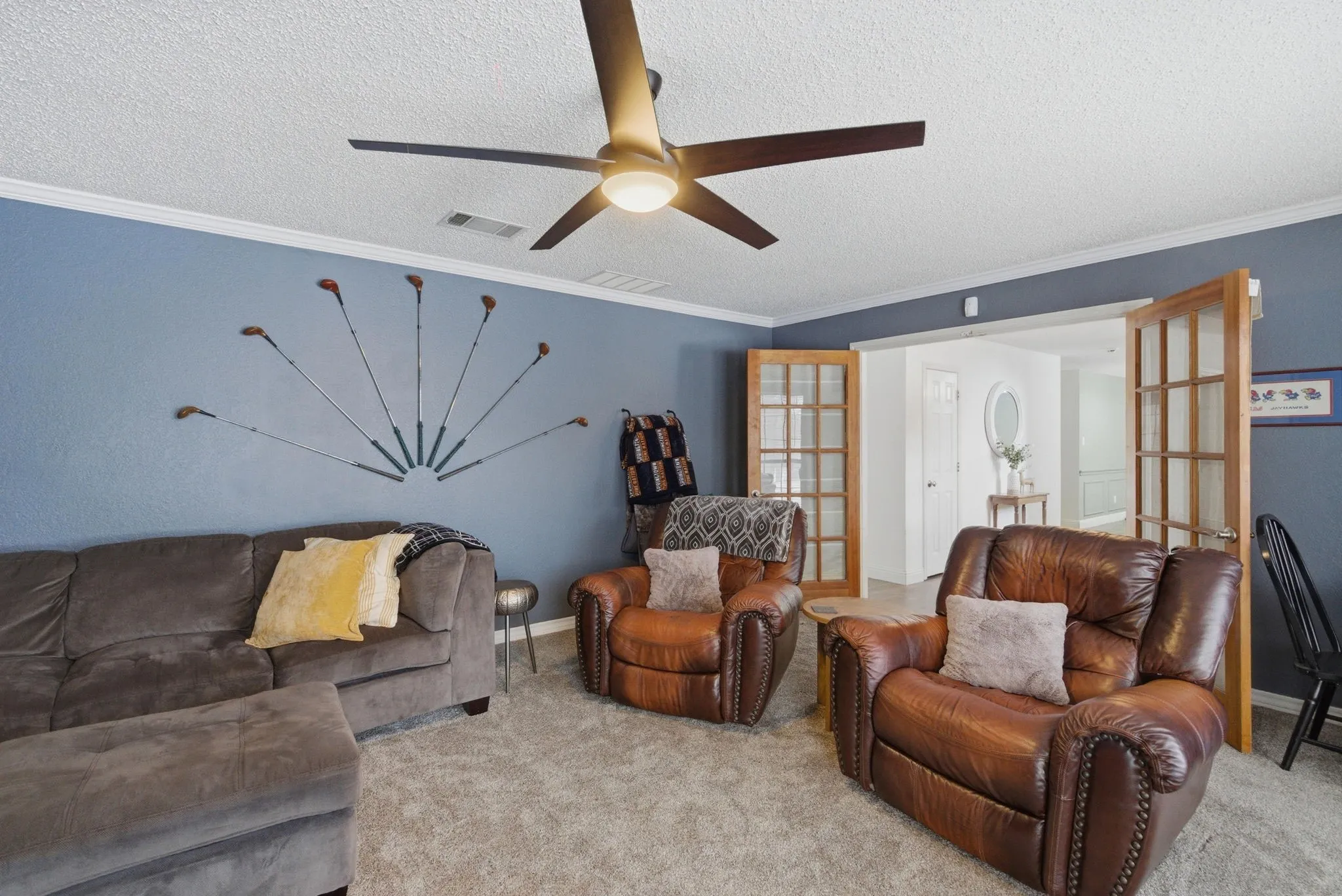 Spacious room featuring textured carpeting and a ceiling fan with integrated lighting