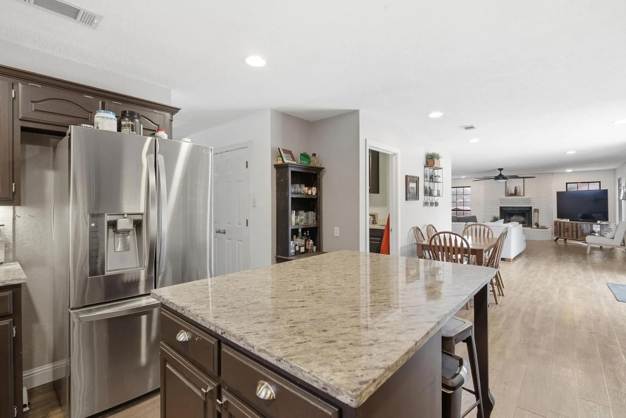 Kitchen island with a granite countertop and dark wood cabinetry