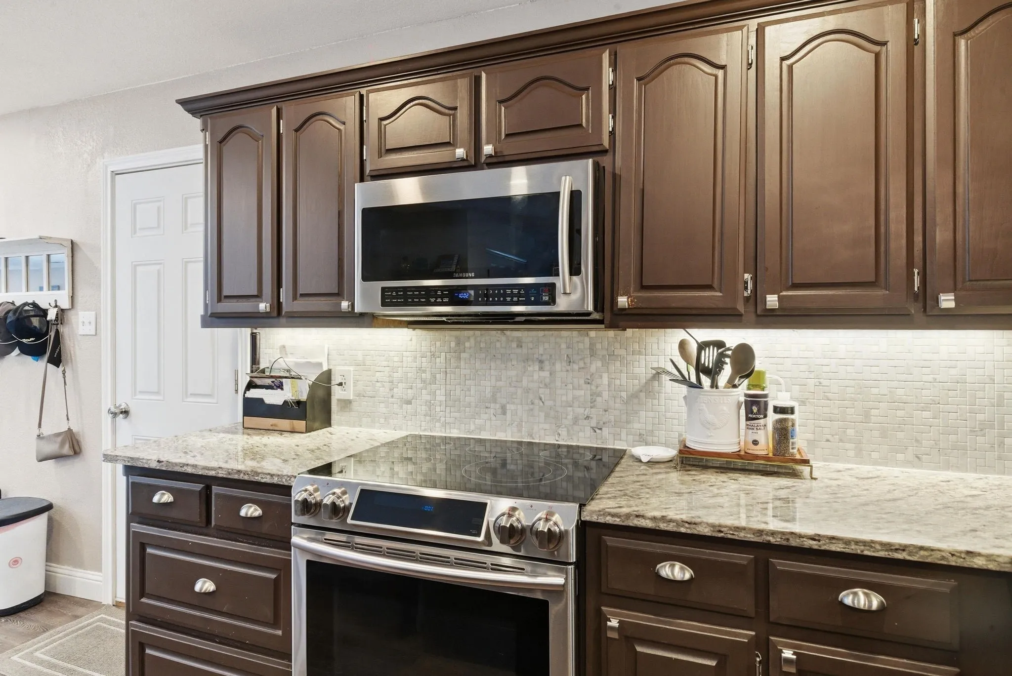 Dark wood cabinetry featuring raised panel doors and silver-tone hardware