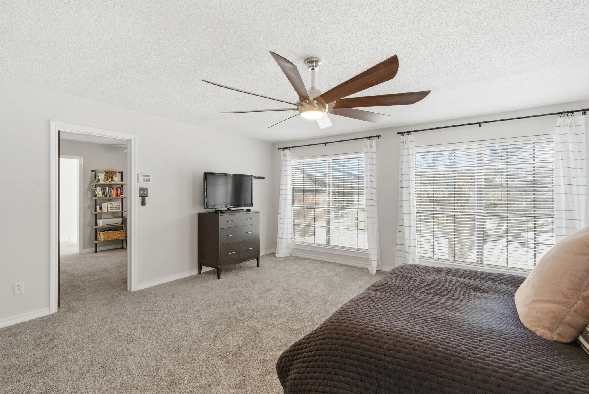 Bright room featuring twin windows, light gray walls, and plush gray carpet
