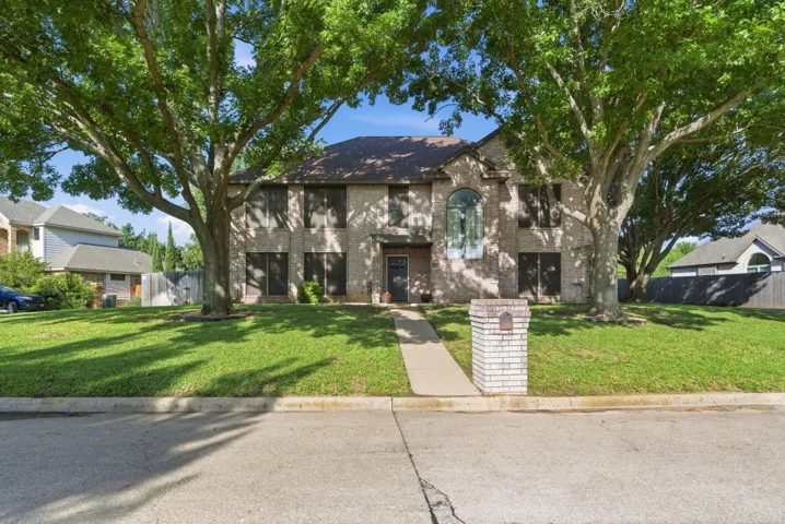 Two-story brick exterior featuring a prominent arched window and a classic shingle​​‌​​​​‌​​‌‌​‌‌​​​‌‌​‌​‌​‌​​​‌​​ roof