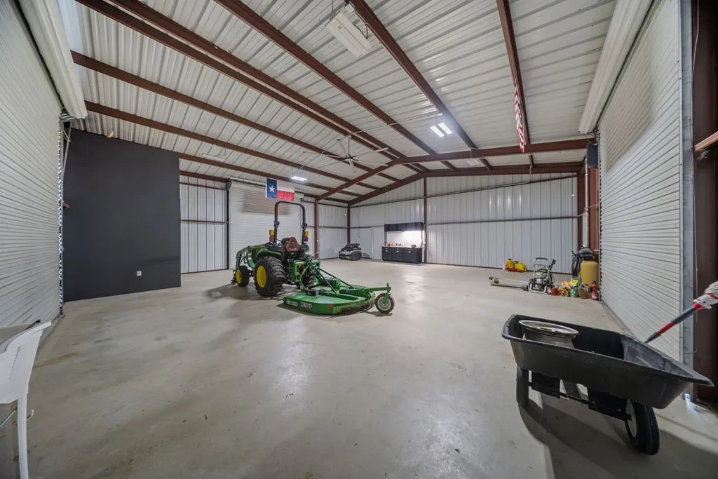 Spacious interior featuring a concrete floor, exposed metal beam construction, and corrugated metal walls