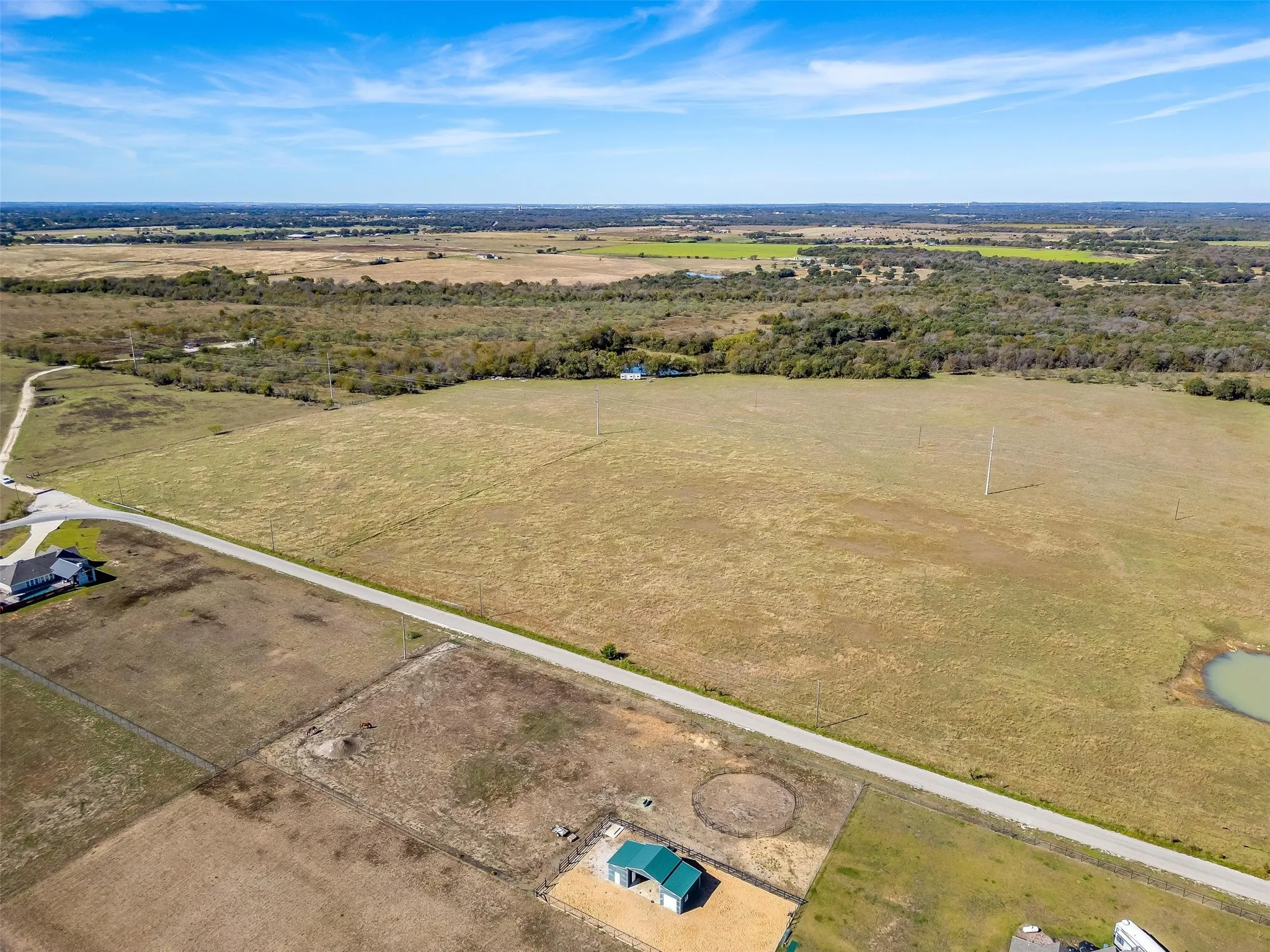 Expansive rural property featuring open fields and distant tree lines