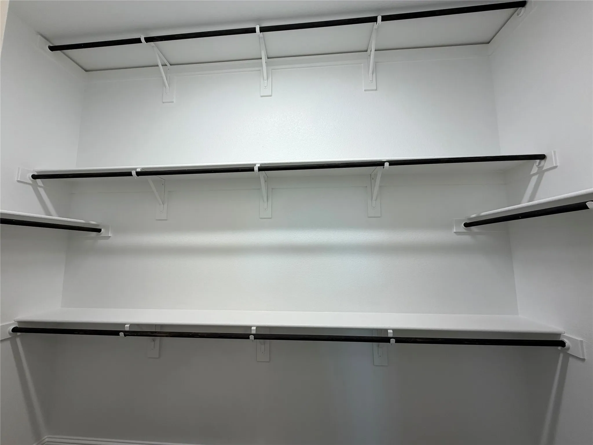 Large master closet with 3rd rod for seasonal storage