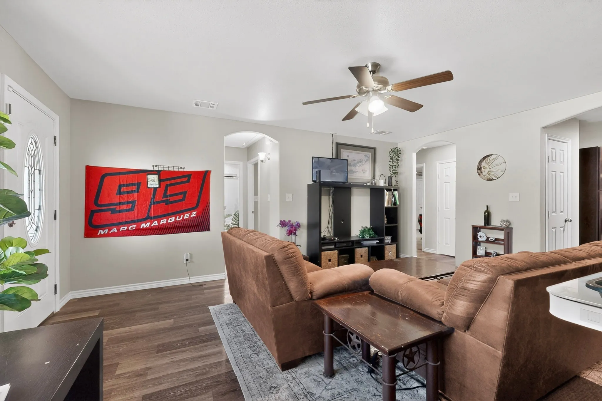 Spacious living area featuring wood-finish flooring, light gray wall paint, and recessed lighting