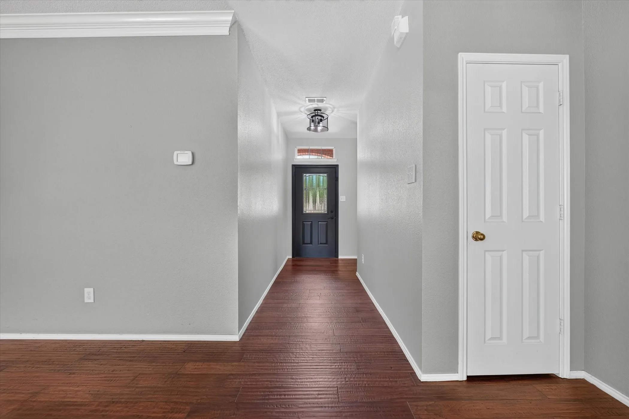 The entry has a beautiful door and engineered wood flooring