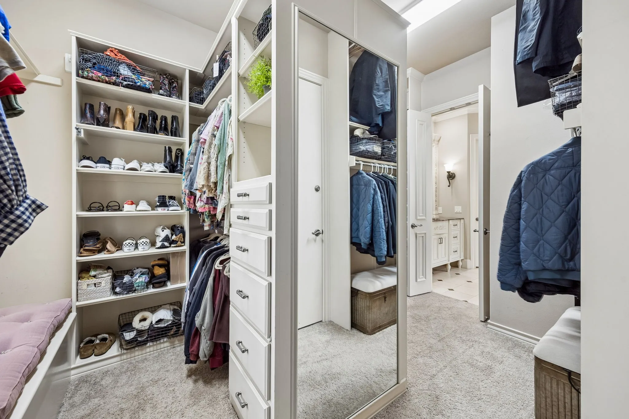 Walk-in closet featuring built-in shelving, drawers, and hanging rods for extensive storage