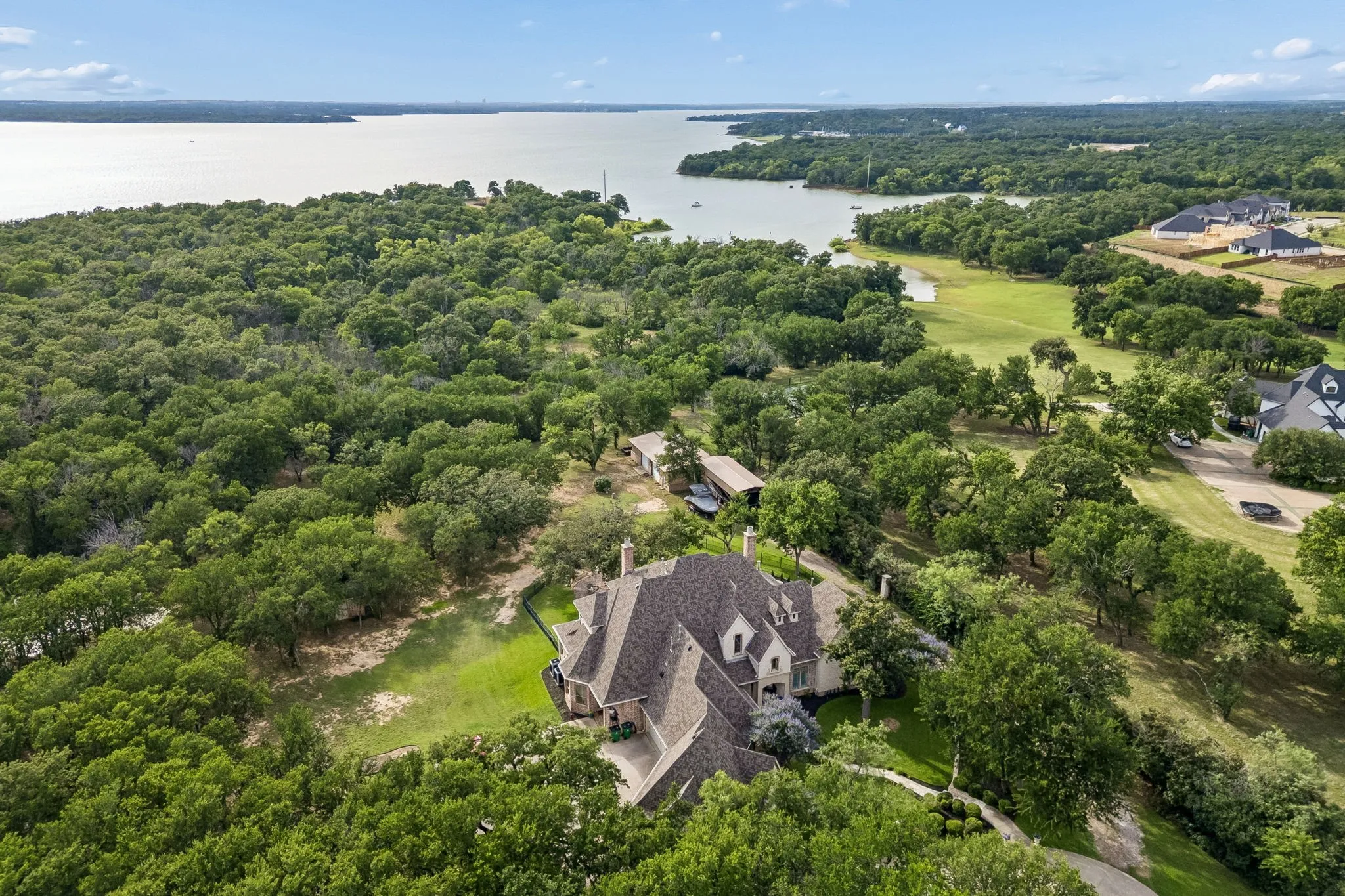 Expansive property with a multi-level roofline and gabled dormers, surrounded by mature trees