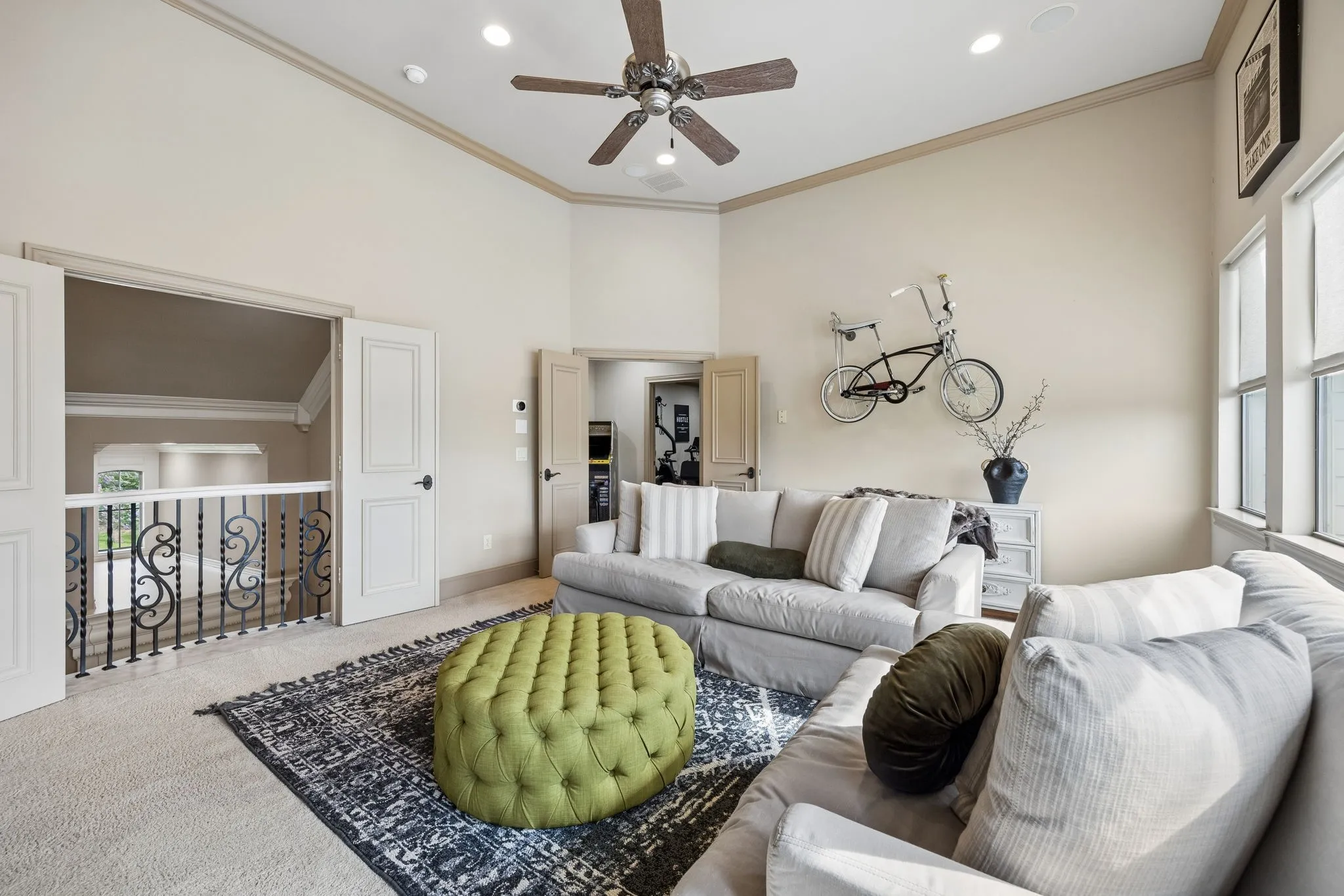 Spacious room featuring vaulted ceilings, light neutral wall tones, multiple windows, recessed lighting, and a ceiling fan