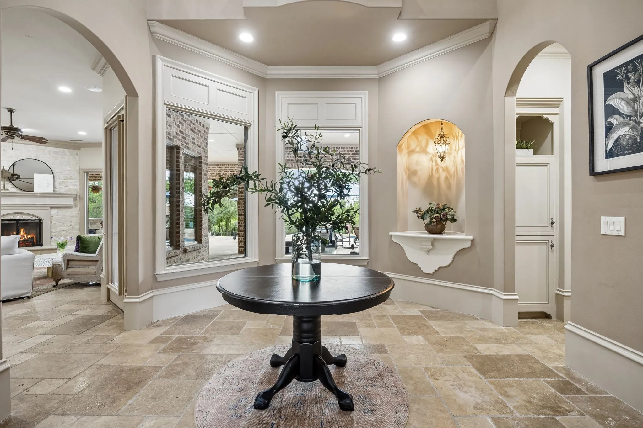 Foyer with stone flooring, an illuminated arched niche, built-in cabinetry, and window framing