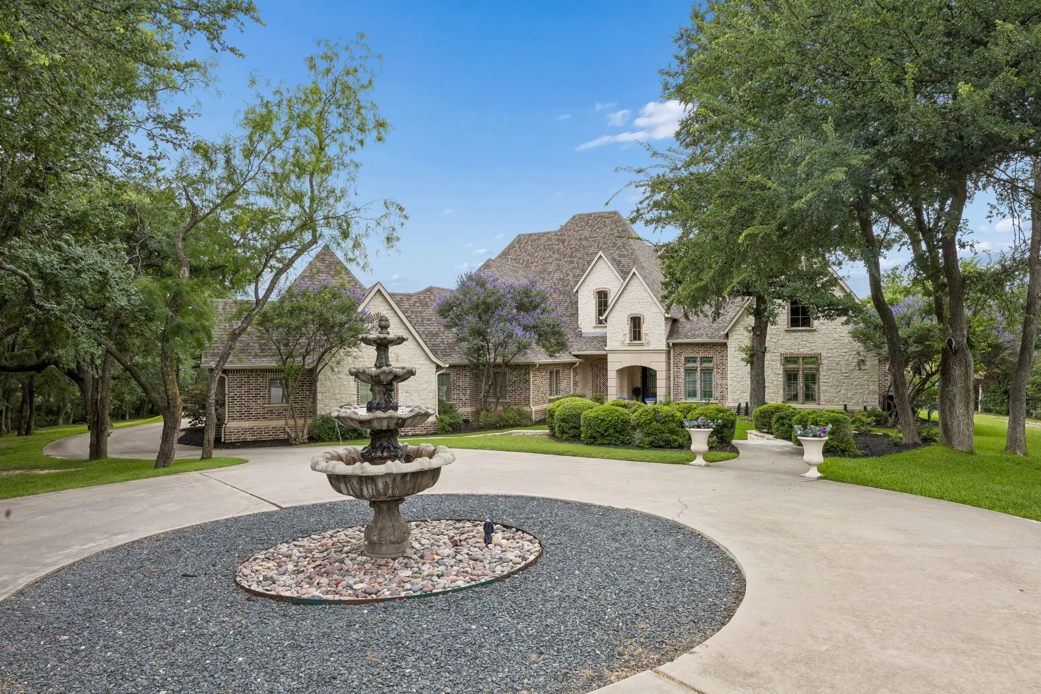 Stone and brick multi-story exterior with a circular drive