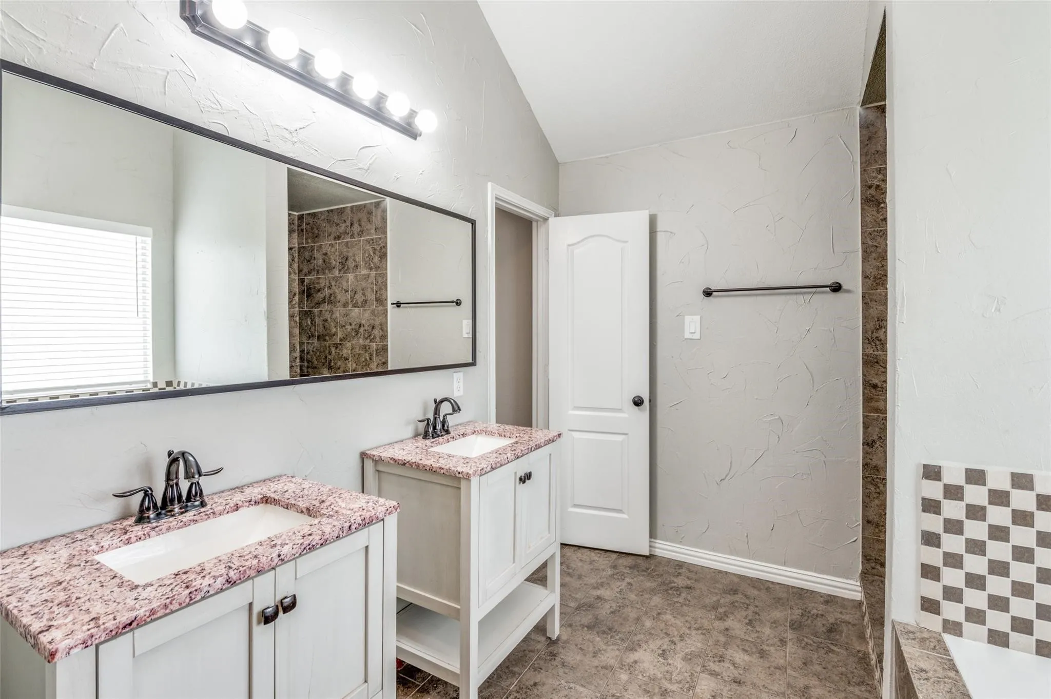 Dual vanity with granite countertops, undermount sinks, and oil-rubbed bronze fixtures