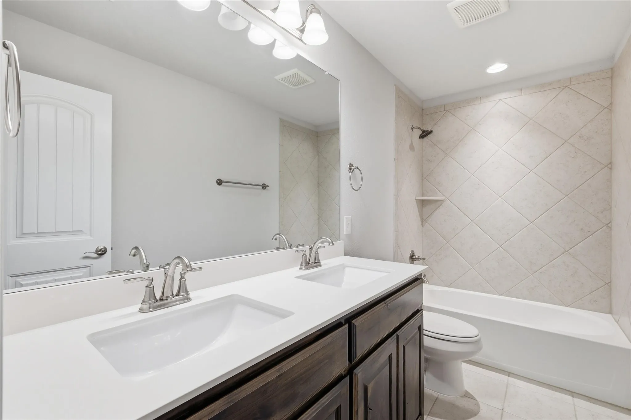 Dual vanity with undermount sinks, bright white countertop, and dark wood-finish cabinetry
