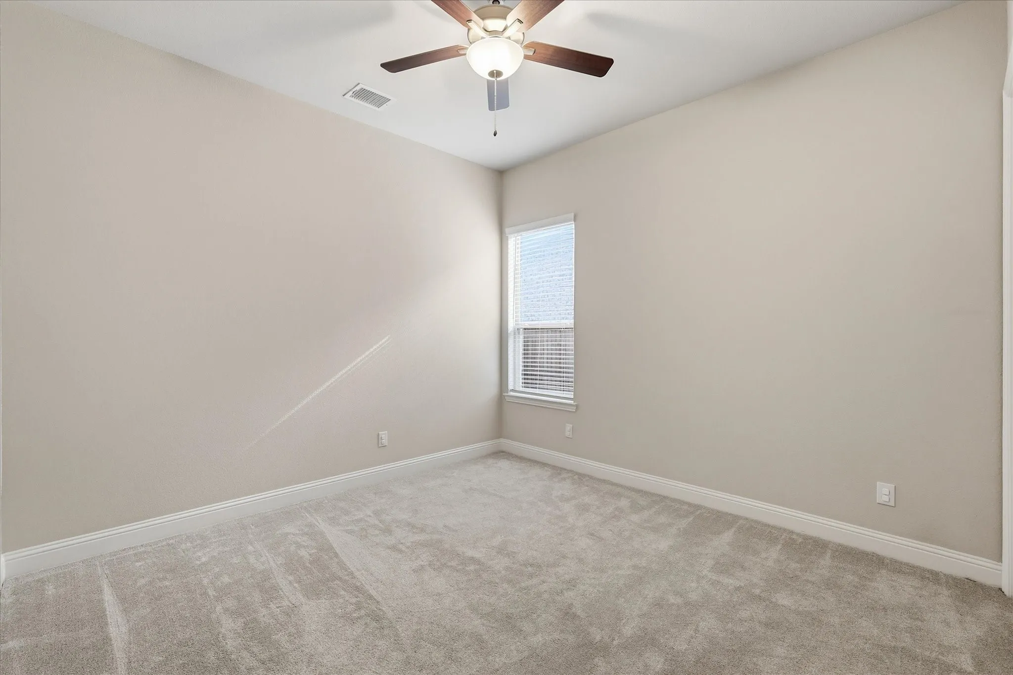 Neutral-toned walls complement the light-colored carpet flooring