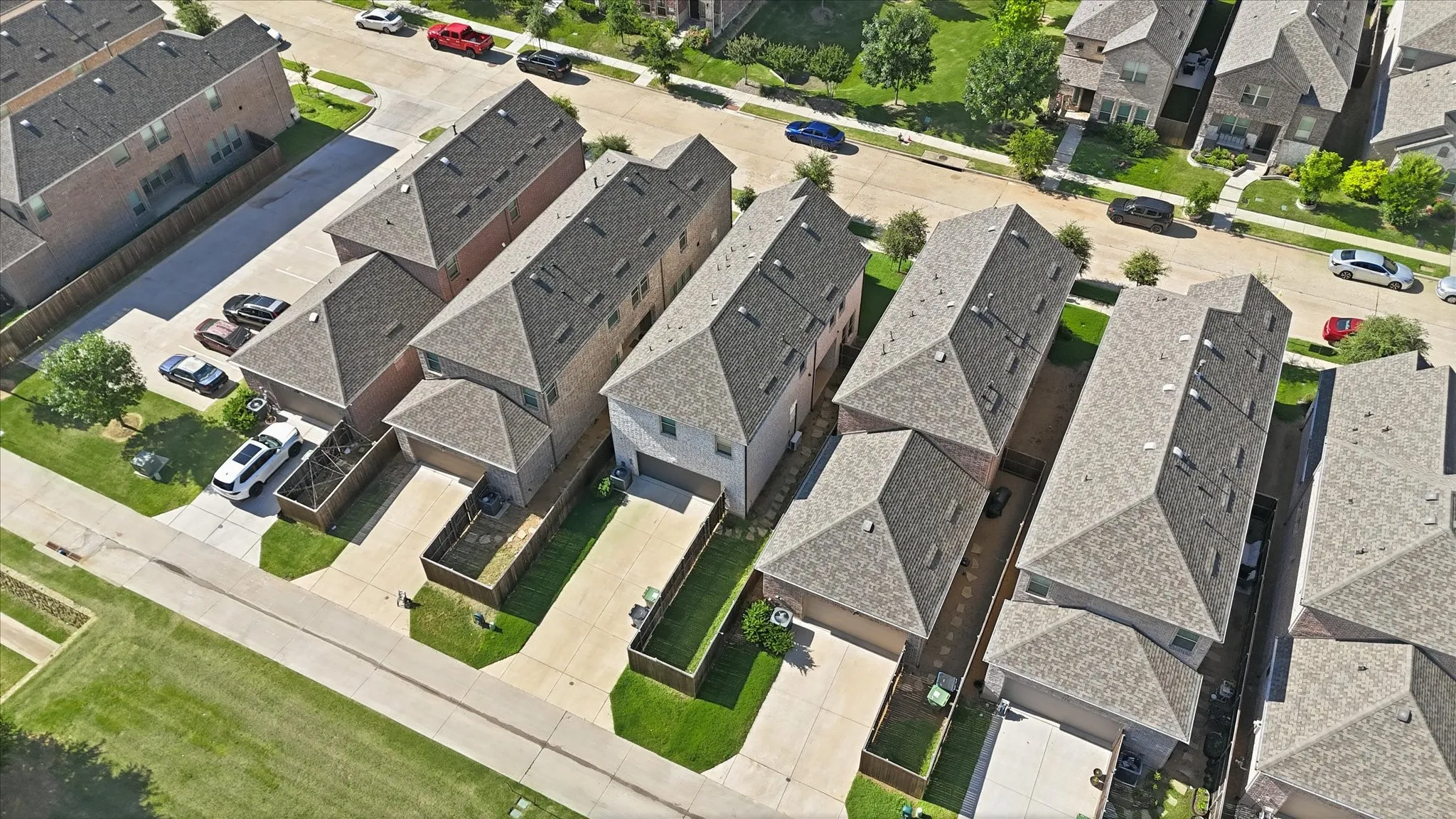 Aerial perspective showcasing multiple properties featuring shingle roofing