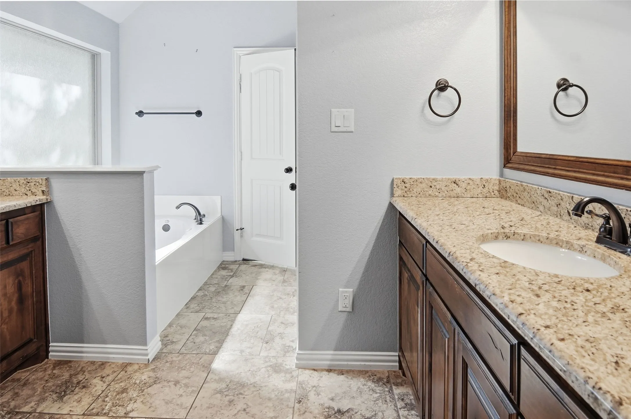Primary Bathroom, granite counters, tile floors, jetted tub and separate shower